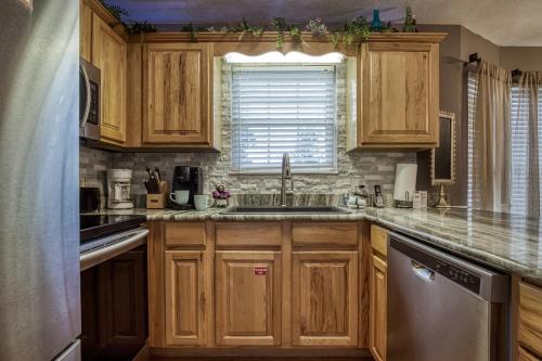 a kitchen with wooden cabinets and a sink and a window at Striking Waters in Pigeon Forge