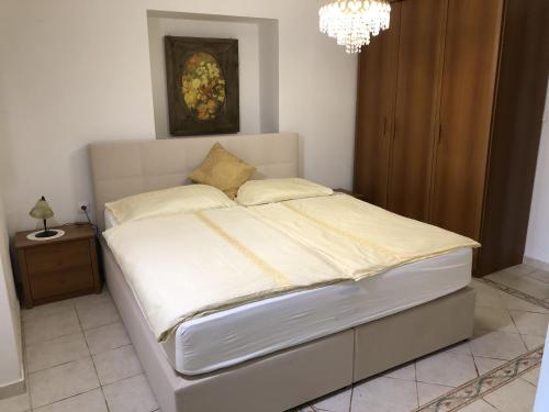 a bed in a bedroom with a chandelier at Villa Anna in Savudrija