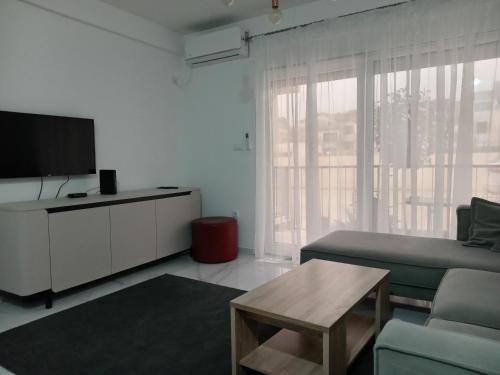 a living room with a couch and a tv and a table at Green lime in Tivat