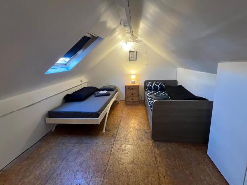 una piccola camera mansardata con letto e divano di European District Apartment Thirteen a Bruxelles