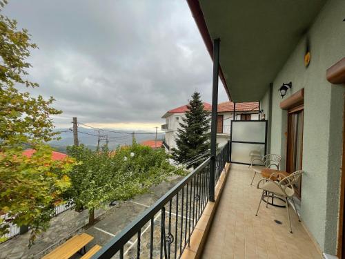 a balcony with a table and chairs on a building at Mamali Guesthouse in Verdikoússa