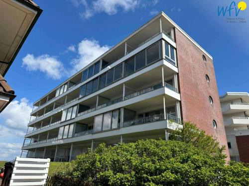 Un edificio de apartamentos con balcones a los lados. en Haus Poseidon Ferienwohnung 4 1, en Wangerooge