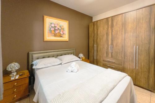 a bedroom with a large white bed with two towels on it at Apartamento Bem Localizado na Cerro Azul in Maringá