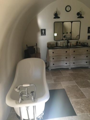 une salle de bain avec une baignoire, un lavabo et un miroir dans l'établissement Mas des Gémeaux, à Ménerbes