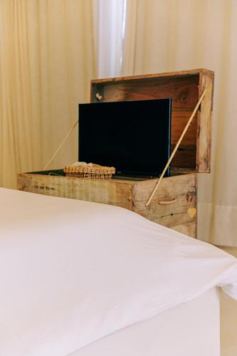 a tv in a wooden box in a bedroom at Anacardier Privé Hotel in Atins