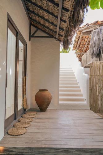 a porch with a large vase on the side of a house at Anacardier Privé Hotel in Atins