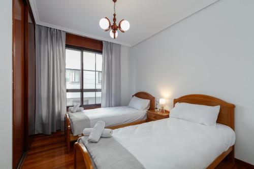 a bedroom with two beds and a window at Con parking y para 6 huéspedes by CABANA Rentals in Cangas de Morrazo