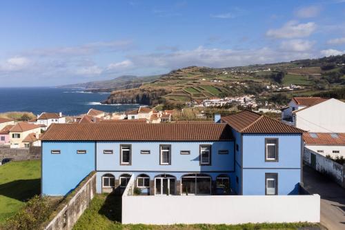 a blue house with a view of the ocean at Casa Formosa - HOST & CHILL in Porto Formoso