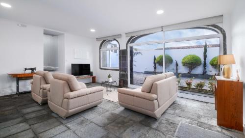 a living room with two chairs and a large window at Casa Formosa - HOST & CHILL in Porto Formoso