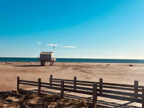 a wooden fence on a beach with the ocean at Bas de Chalet Santa Giulia in Gruissan