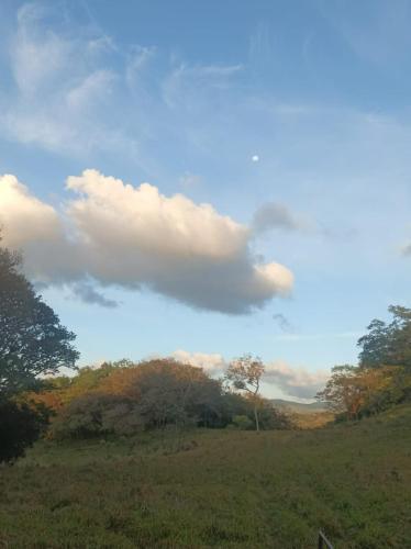 a cloud in the sky over a field at Hospedaje Rancho mi Tata in Solania