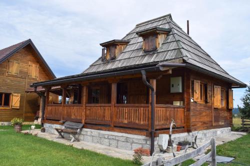une grande maison en bois avec un toit en gambrel dans l'établissement Zlatiborsko srce, à Čemerikovci