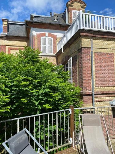 une maison avec une clôture et un banc devant elle dans l'établissement Terrasse front de mer, à Villers-sur-Mer
