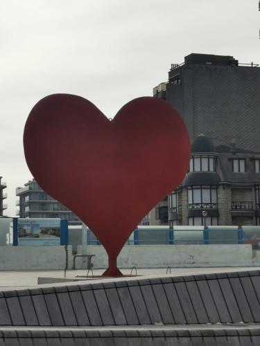 a red heart statue in the middle of a city at Studio sur la digue in Middelkerke