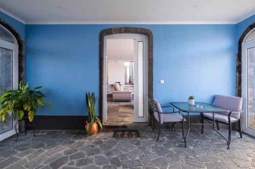 a dining room with blue walls and a table and chairs at Casa Formosa - HOST & CHILL in Porto Formoso