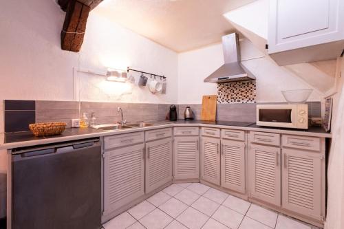 une cuisine avec un évier et un micro-ondes dans l'établissement Charmant Duplex Coeur Historique, à Rennes