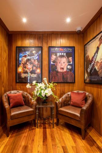 a living room with two chairs and movie posters at Pax Manor Muthaiga in Nairobi