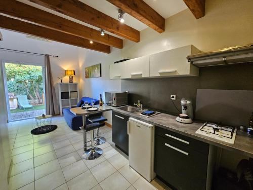 une cuisine avec un évier et un plan de travail dans l'établissement Gîte Les Palmiers L'Escapade Des Flamants Roses, à Mireval