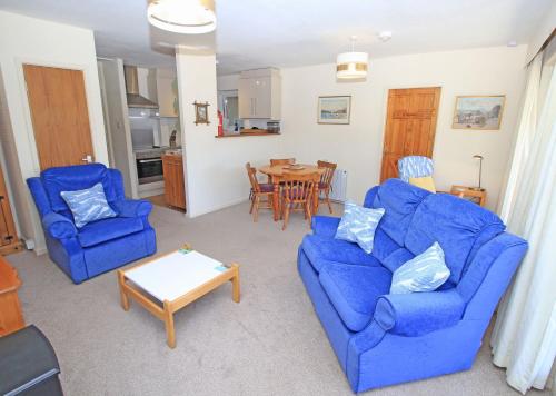 a living room with two blue couches and a table at Glaslyn Harbour Views in Porthmadog