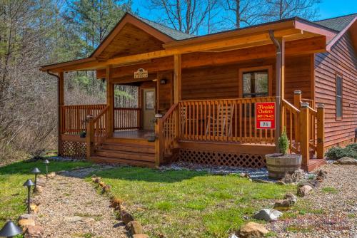 a log cabin with a front porch and a for sale sign at Bear Run in Sevierville