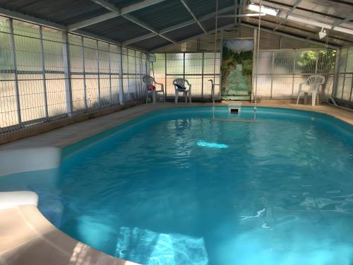 une grande piscine avec de l'eau bleue dans un immeuble dans l'établissement Villa la Myreclose, à Saint-Auban