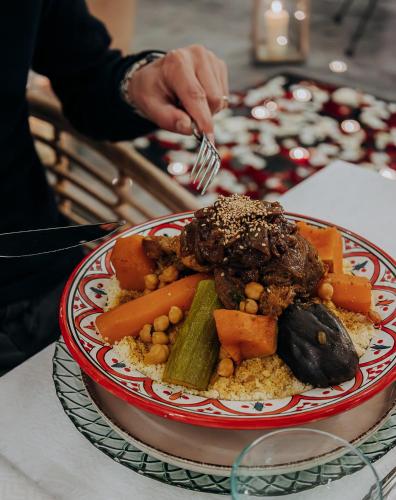 a plate of food with meat and vegetables on a table at Riad Villa Wengé & Spa in Marrakech