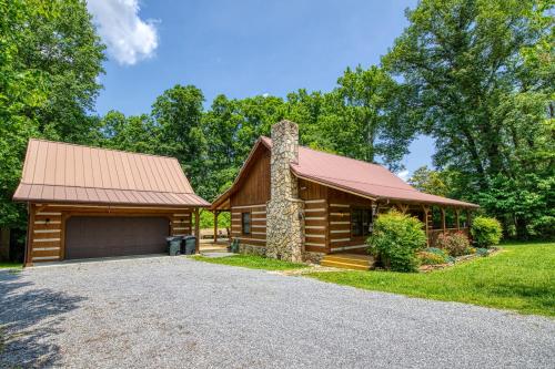 une cabane en rondins avec un garage et une allée dans l'établissement 4 Paws Lodge, à Sevierville