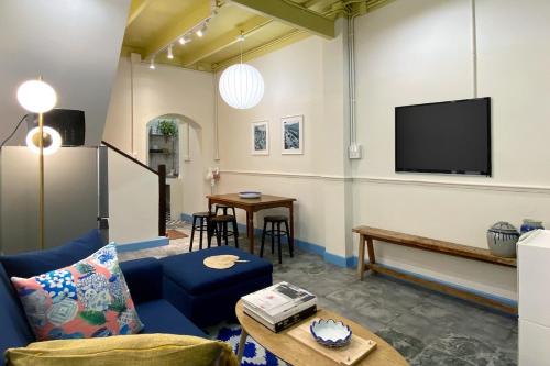 a living room with a tv and a couch and a table at BaanBaan - Cozy home 5pax, 5min BTS, Boat, old town explore in Bangkok