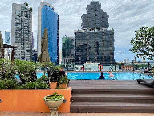 a swimming pool in a city with tall buildings at BaanBaan - Cozy home 5pax, 5min BTS, Boat, old town explore in Bangkok