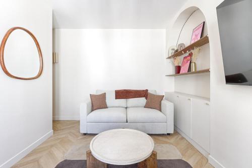 un salon avec un canapé blanc et une table dans l'établissement Barbès Buttes Chaumont Cosy Studio 2P, à Paris