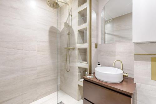 une salle de bain avec un lavabo et une douche dans l'établissement Barbès Buttes Chaumont Cosy Studio 2P, à Paris