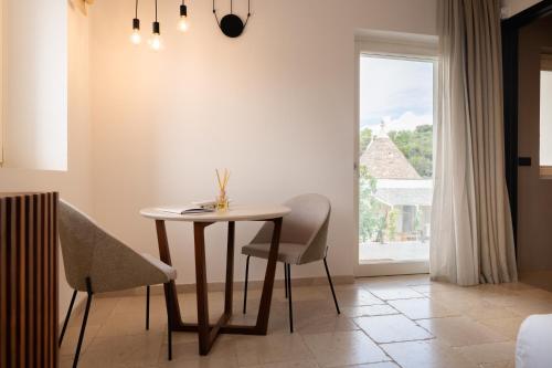 a dining room with a table and chairs and a window at Essenza Relais Contemporaneo in Cisternino