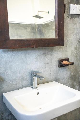 a bathroom sink with a mirror and a mirror at Cocos in Midigama