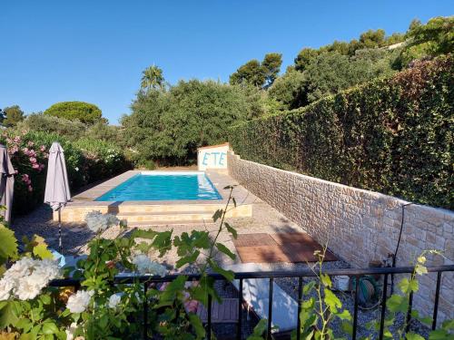 un jardin avec une piscine et une clôture dans l'établissement Mas Chamarel, la Provence entre vignes et oliviers proche de la mer, à Sanary-sur-Mer