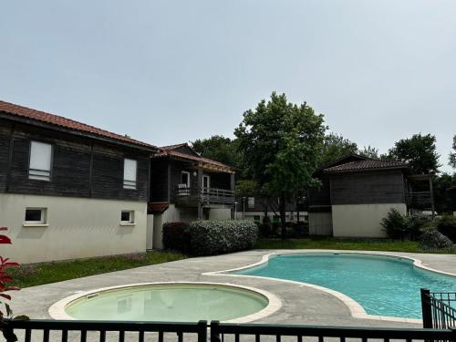 une piscine devant une maison dans l'établissement Aureilhan T2 50m2, 6 pers, wifi, piscine résidence, à Aureilhan