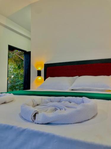 a bed with a white blanket on top of it at Cozy forest ella in Ella