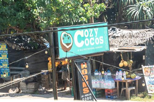 a sign for a cocacola store on the street at Cocos in Midigama
