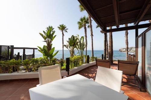 a patio with a table and chairs and the ocean at Suite Altamar - by Gestión Vacacional Canarias in Playa del Aguila