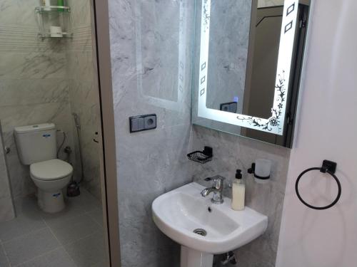 a bathroom with a sink and a toilet and a mirror at Casa Salvador 1 boujdour in Cabo Bojador