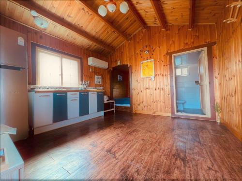 a large kitchen with wooden walls and a wooden floor at Taean loghouse pension in Taean