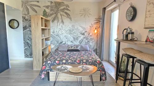 une chambre avec un lit et une table dedans dans l'établissement Les Coralies, à Sainte-Maxime