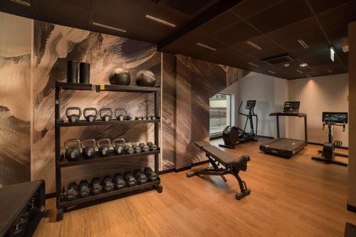 a room with a gym with a bench and weights at NH Milano Corso Buenos Aires in Milan