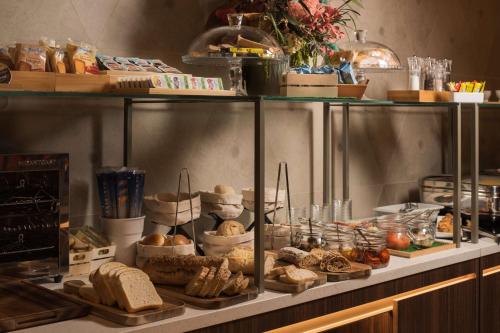 a buffet with bread and other food on a counter at NH Milano Corso Buenos Aires in Milan