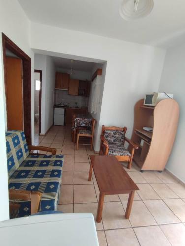 a living room with a couch and chairs and a table at Argiro's Studios A1 in Kefalos