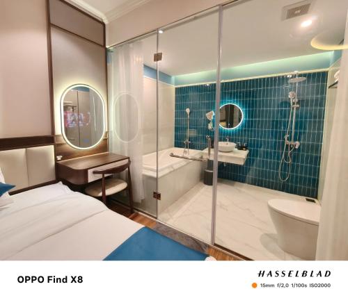 une chambre d'hôtel avec une salle de bain avec un lit et une douche dans l'établissement CORDELIA HA LONG Hotel, à Hạ Long