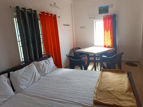 a bedroom with a bed and a table with chairs at Dam Valley Home Stay Resort in Parambikolam