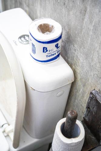 a toilet with a roll of toilet paper on it at Cocos in Midigama