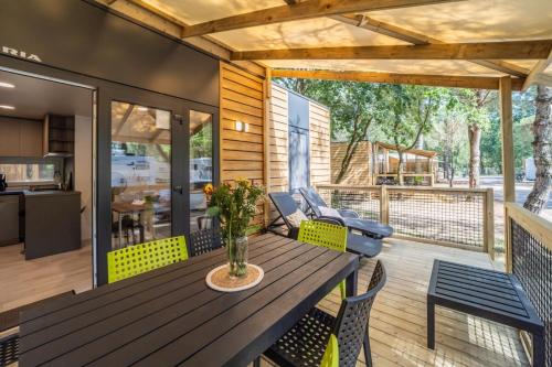 une terrasse avec une table et des chaises en bois dans l'établissement Camping maeva Respire Les Couleurs de la Coubre, aux Mathes