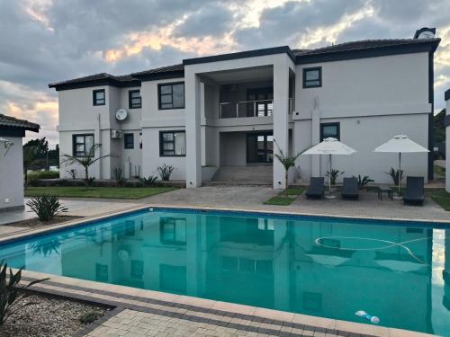 a house with a swimming pool in front of it at Sagwadi Hotel in Hazyview