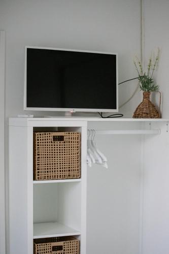 a tv on a white shelf with a television at Rêve Champenois Chambres d'Hôtes in Rilly-la-Montagne